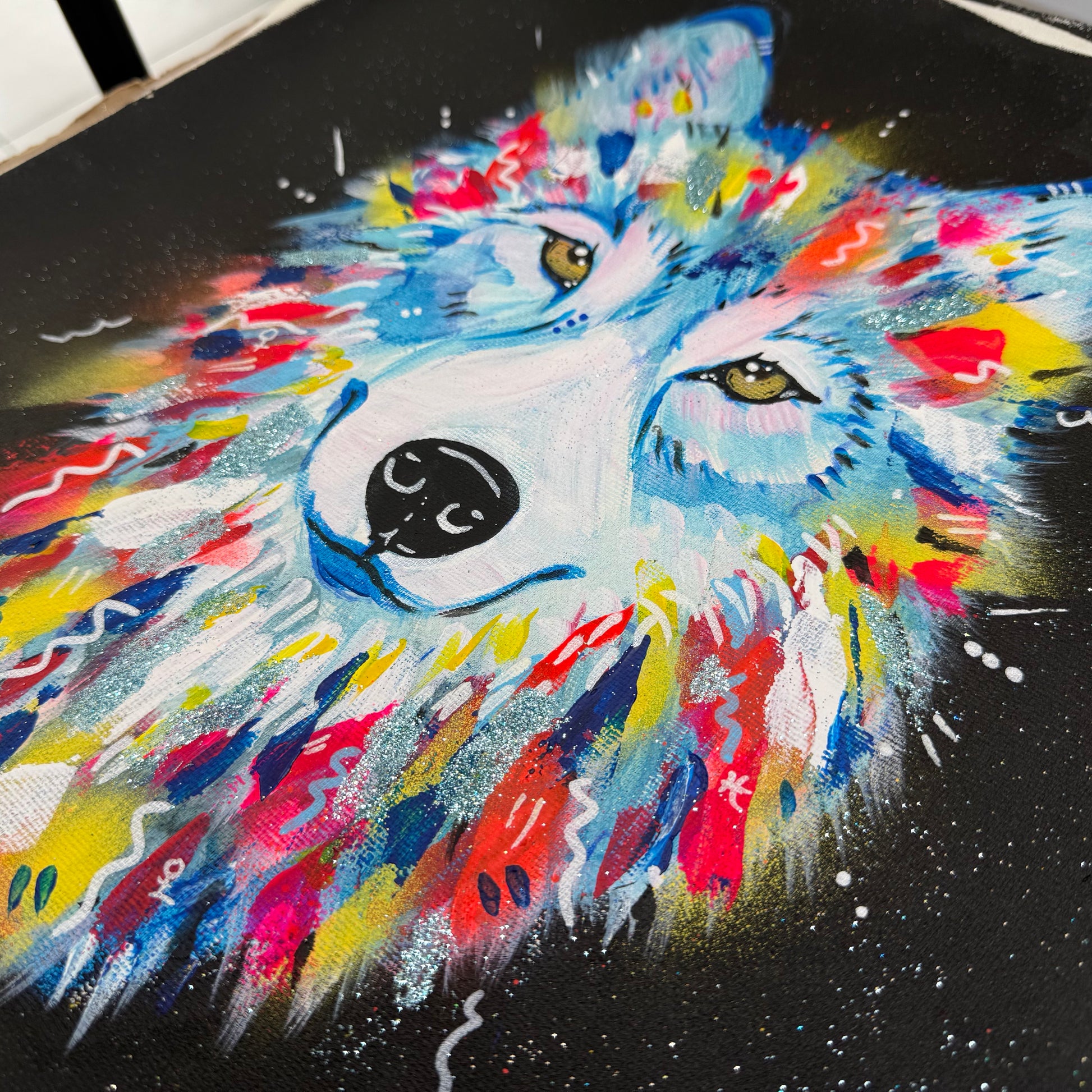 Détail d’un art print représentant un loup coloré, texture de la peinture et finesse de l’impression fine art sur toile coton